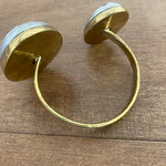 Gold hoop earrings on a wooden surface