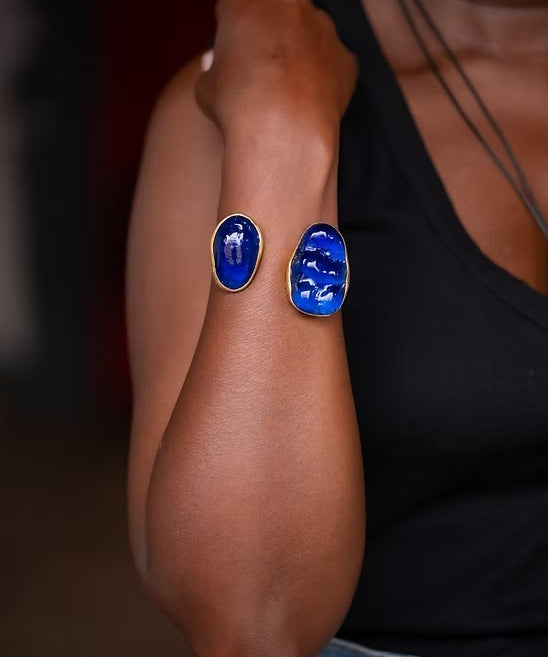 Person wearing blue oval earrings on a blurred background