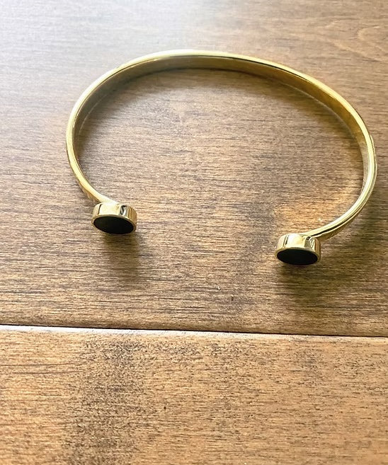 Gold bracelet on a wooden surface