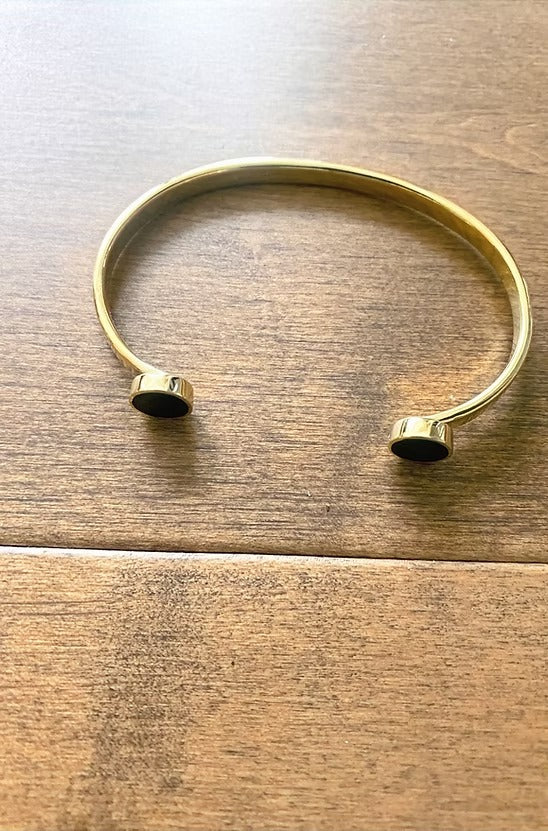 Gold bracelet on a wooden surface