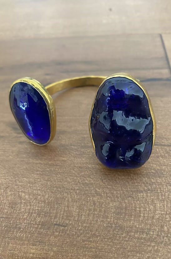 Gold bracelet with blue stones on a wooden surface